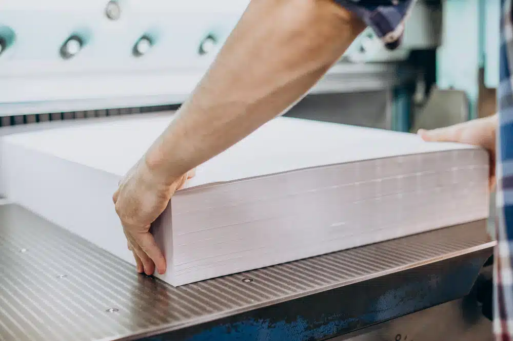 Person handling a large stack of paper